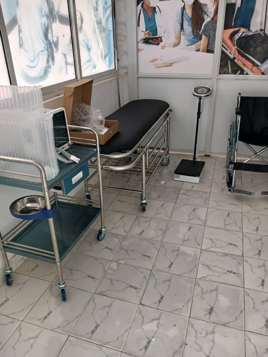 Examination room fitted with couch, trolley, monitor, scale and wheelchair