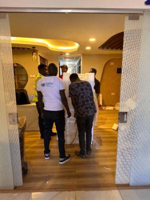 Two Jodroc staff delivering a biosafety cabinet along a clinic corridor